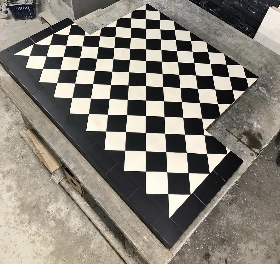 Black and white chequerboard Victorian tiled hearth with a black border, freshly made in the workshop